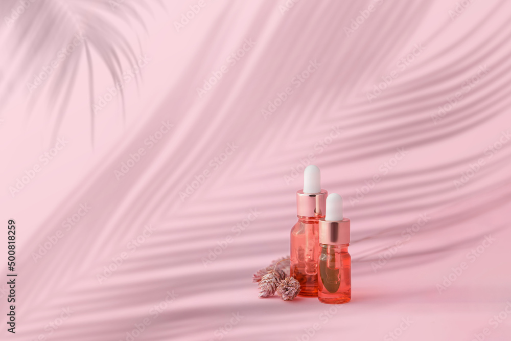 Bottles of natural serum on pink background with space for text Bottles of natural serum on pink background with space for text