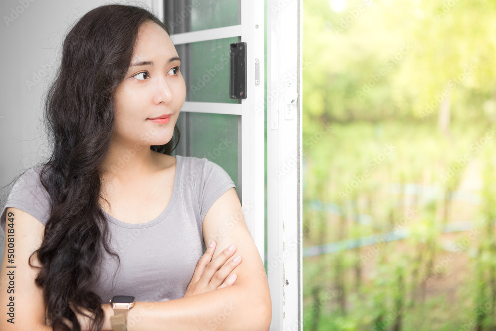 Beautiful Asian business woman wearing grey casual shirt relaxing at the window and admiring nature and copy space. Confident Asian working woman smiling and cheerful Beautiful Asian business woman wearing grey casual shirt relaxing at the window and admiring nature and copy space. Confident Asian working woman smiling and cheerful
