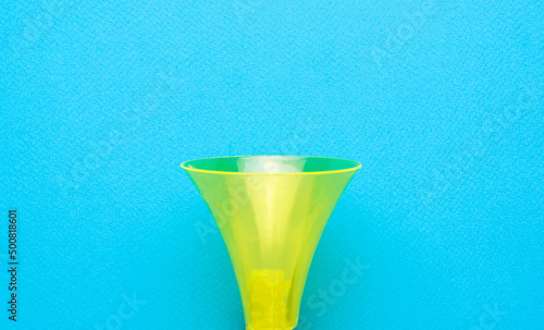 A yellow bicycle horn trumpet on a blue background. Flat lay. photo