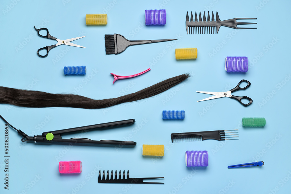 Composition with hair strand, hairdresser's tools and curlers on blue background