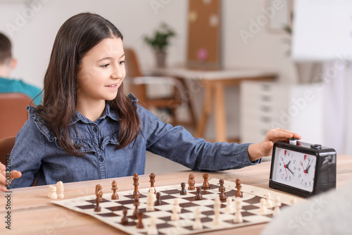 Little girl playing chess d...