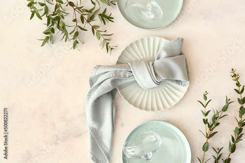 Stylish table setting and eucalyptus branches on light background