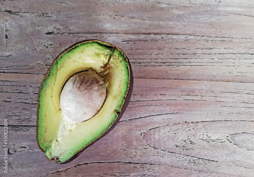 Fresh opened,cut off avocado fruit, placed on  brown wooden background