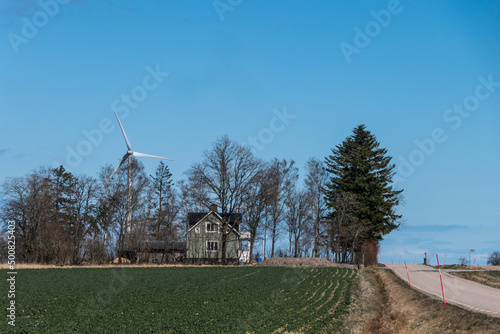 Grindstad, Sweden A wind turbine towers over a farmhouse. photo