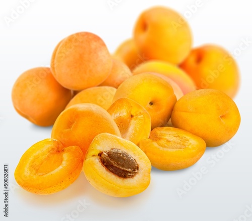 Orange fresh ripe apricots with leaves on a wooden table