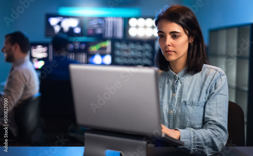 Young caucasian woman working in the office using laptop. Financial analyst  trader and stock market.