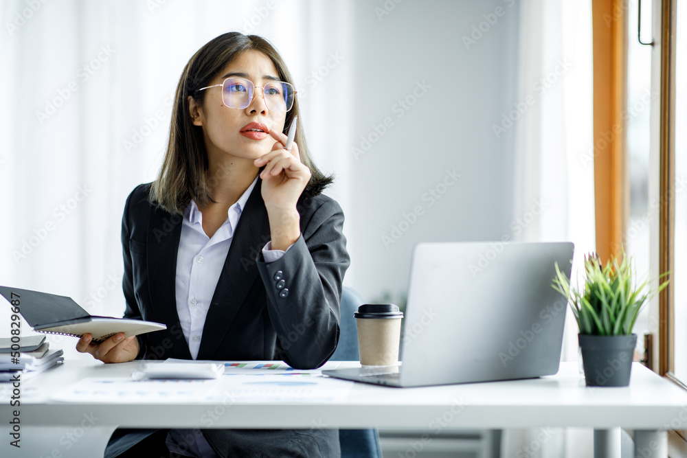 Portrait of young Asian businesswoman using write notebook laptop in home office. Beautiful girl at desk computer take home order. Startup business asia woman online sme telemarketing. Portrait of young Asian businesswoman using write notebook laptop in home office. Beautiful girl at desk computer take home order. Startup business asia woman online sme telemarketing.