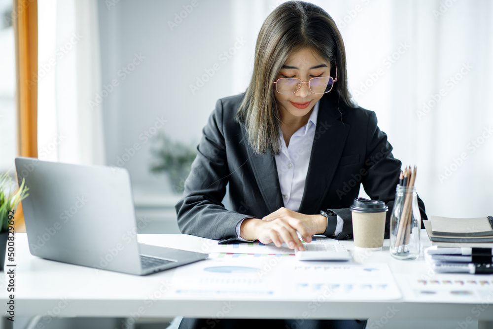 Portrait of young Asian businesswoman using write notebook laptop in home office. Beautiful girl at desk computer take home order. Startup business asia woman online sme telemarketing. Portrait of young Asian businesswoman using write notebook laptop in home office. Beautiful girl at desk computer take home order. Startup business asia woman online sme telemarketing.