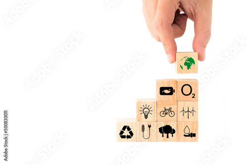 Ideas to save the environment for World Environment Day. hand picking up wooden blocks with Earth icon on top. energy saving, clean energy, reforestation, increase oxygen, reduce fuel consumption.