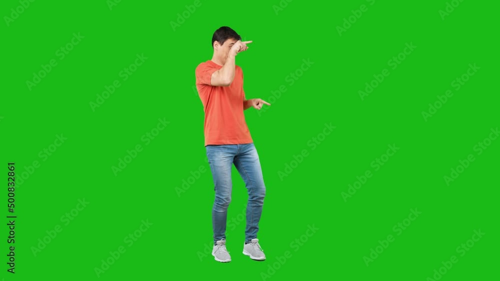 Positive young man pointing aside. Green background Positive young man pointing aside. Green background