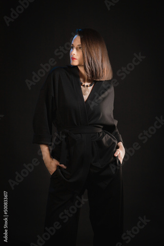 Studio shot of brunette woman 30s wearing black silk pajamas