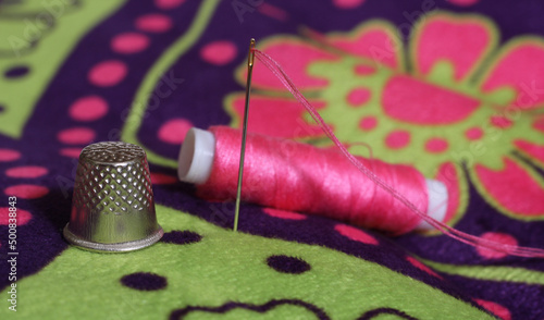 Thimble and Spool of Pink Thread on Vintage Floral Fabric