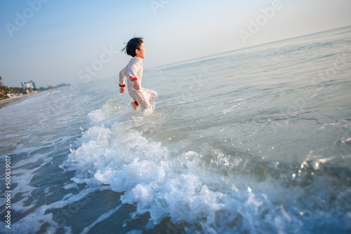 The boy ran to the sea in the morning while still wearing pajamas.