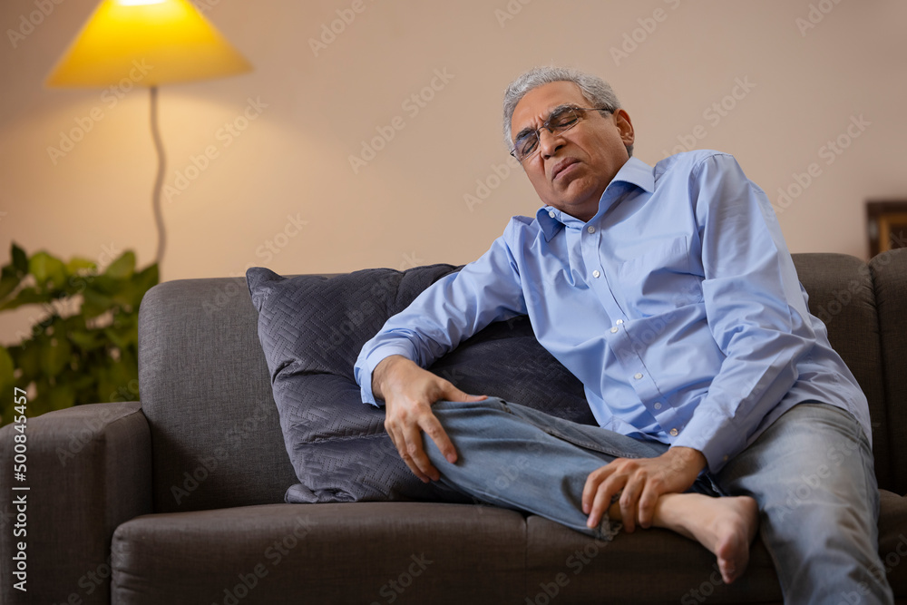 Portrait of a senior man suffering from knee pain Portrait of a senior man suffering from knee pain