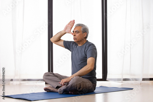 Canvastavla Portrait of an active  senior man doing breathing exercise at home