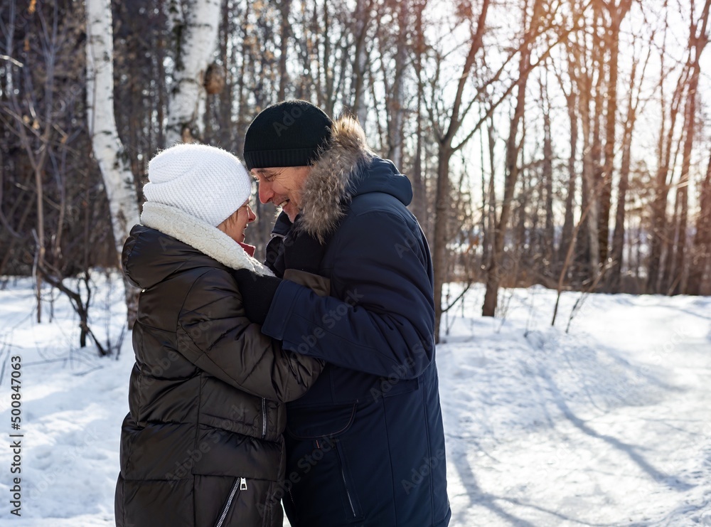 Elderly couple hugging each other in the countryside at sunset in the winter forest, family relationship. Life style Elderly couple hugging each other in the countryside at sunset in the winter forest, family relationship. Life style