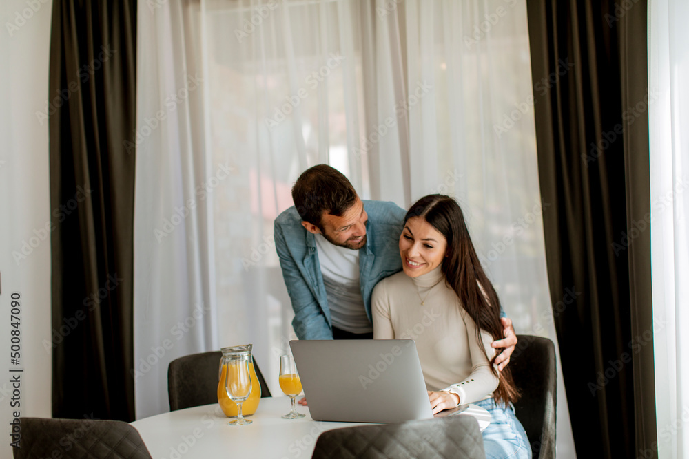 Young couple using laptop computer on the table in the living room