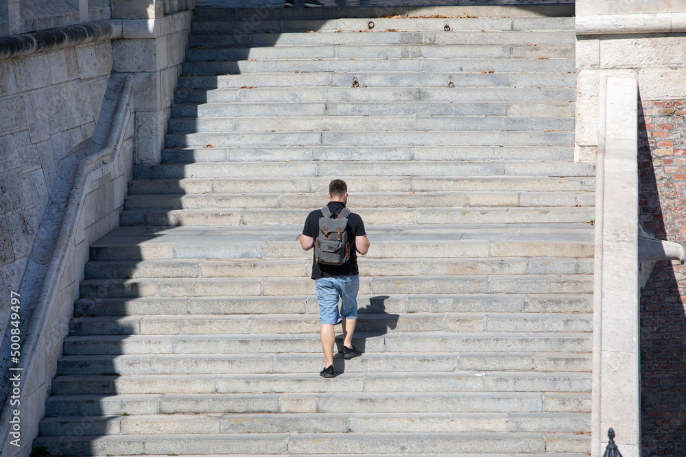 people walking by stone stairs with backpack