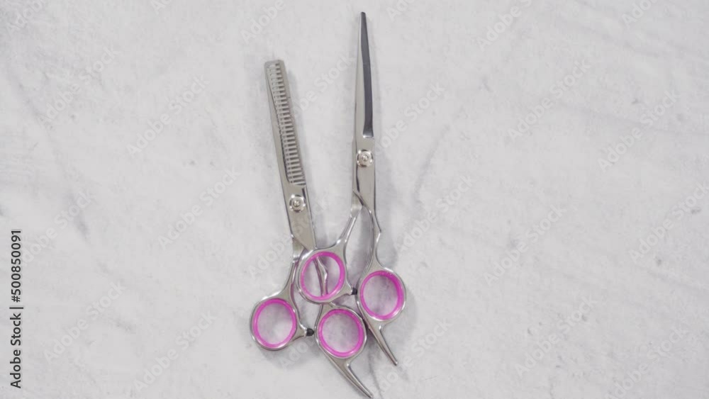 New barber set with pink scissors on a gray background. New barber set with pink scissors on a gray background.