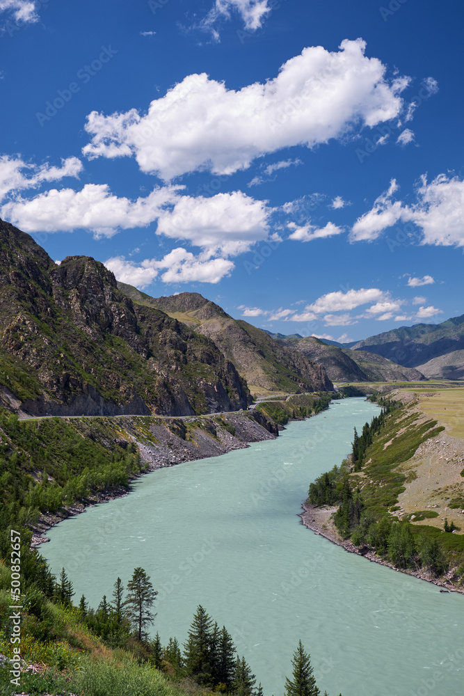 Altai natural landscape with river Katun under blue sky with clouds.