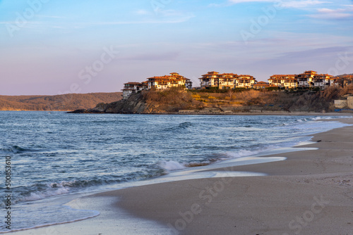 View of the city with buildings on a rocky shore near the Black Sea under sunset