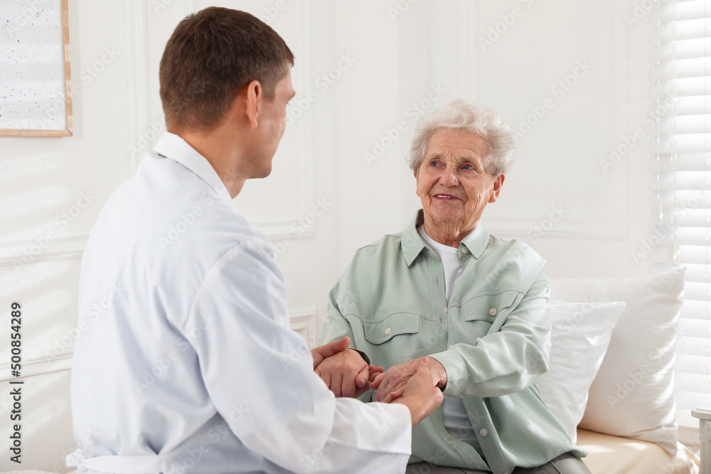 Caregiver talking to senior woman in living room. Home health care service Caregiver talking to senior woman in living room. Home health care service