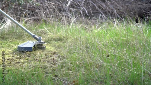 Wallpaper Mural Brushcutter cutting herbs in slow motion in the field. Torontodigital.ca