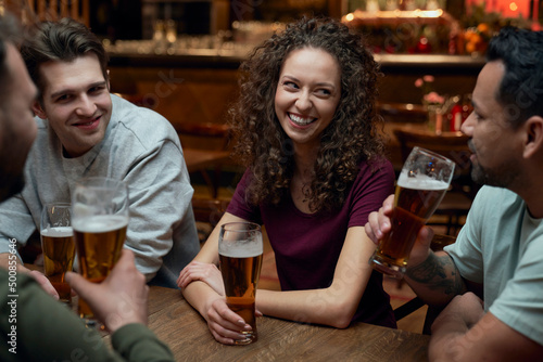Group of friends having beer and socializing in a pub photo