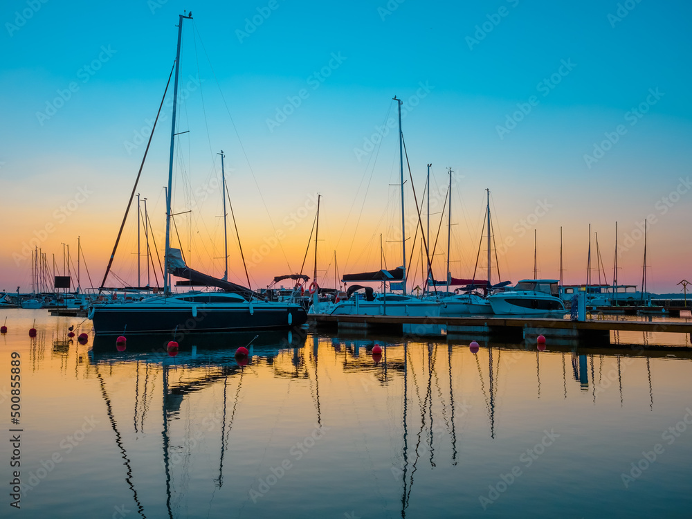 dawn landscape of quayside with jetty full of sailing yachts, calm, tranquil and serenity waterfront view