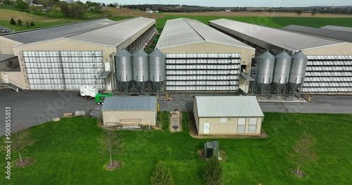 Large barns to house hens and chickens. Egg laying operation at factory farm in USA. Aerial reveals bins with poultry feed. photo