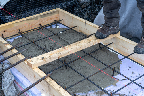 Iron net and wooden formwork with laid under insulation for pouring the foundation. photo