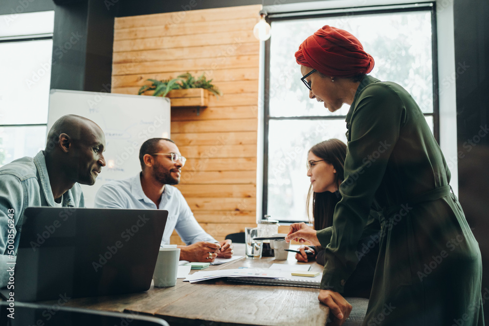 Group of diverse businesspeople having a meeting in a boardroom Group of diverse businesspeople having a meeting in a boardroom