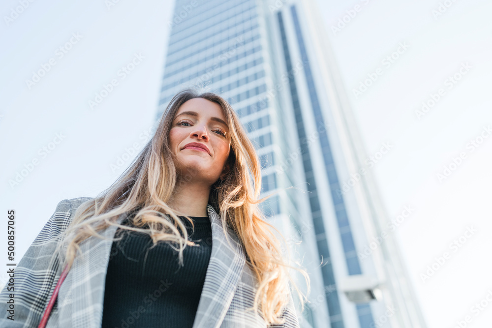 Smiling young woman standing in front of building Smiling young woman standing in front of building