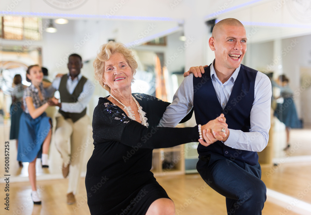 Mature woman learning to dance lindy hop with younger man 
