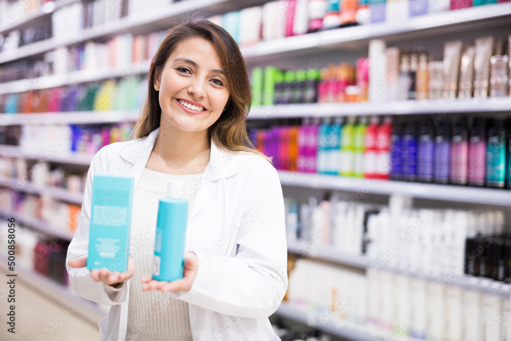 Positive salesgirl helping to choose hair products in cosmetic store Positive salesgirl helping to choose hair products in cosmetic store