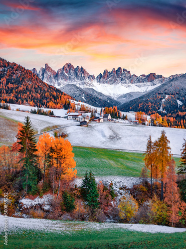 Snowy green hills on Santa Magdalena village with Seceda peak on background. Colorful autumn scene of Dolomite Alps, Italy. Morning view of popular tourist destination - Santa Maddalena church.