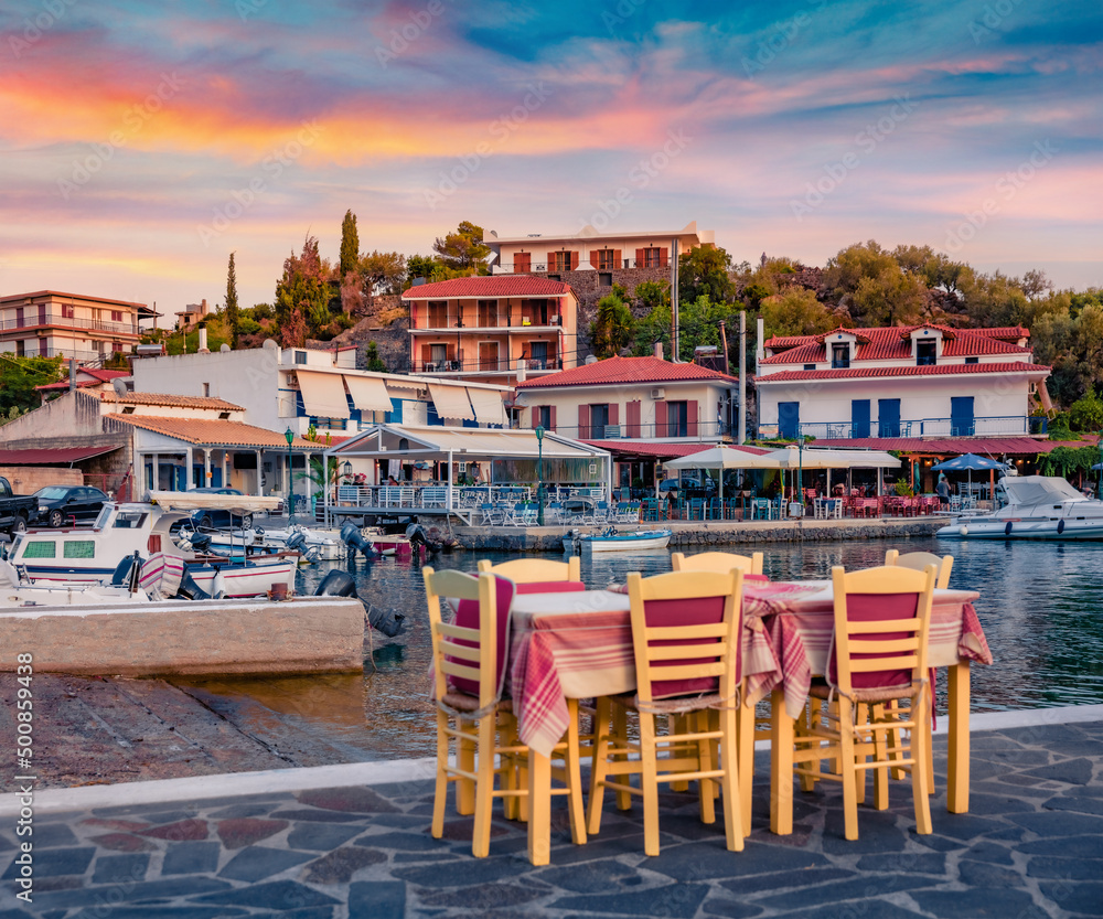 Small quay restaurant in Vathi port. Calm morning scene of Peloponnese peninsula, Greece, Europe. Splendid Ioninan seascape. Traveling concept background.