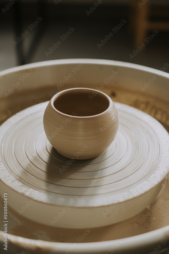 Earthen bowl on potter's wheel in workshop Earthen bowl on potter's wheel in workshop