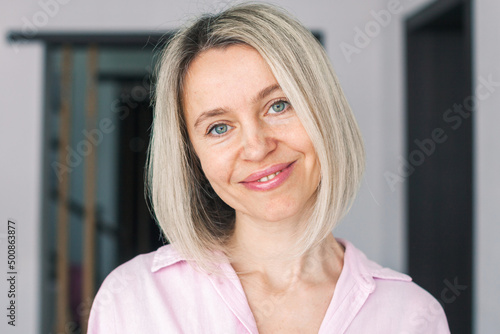 Smiling middle aged mature woman looking at camera at home