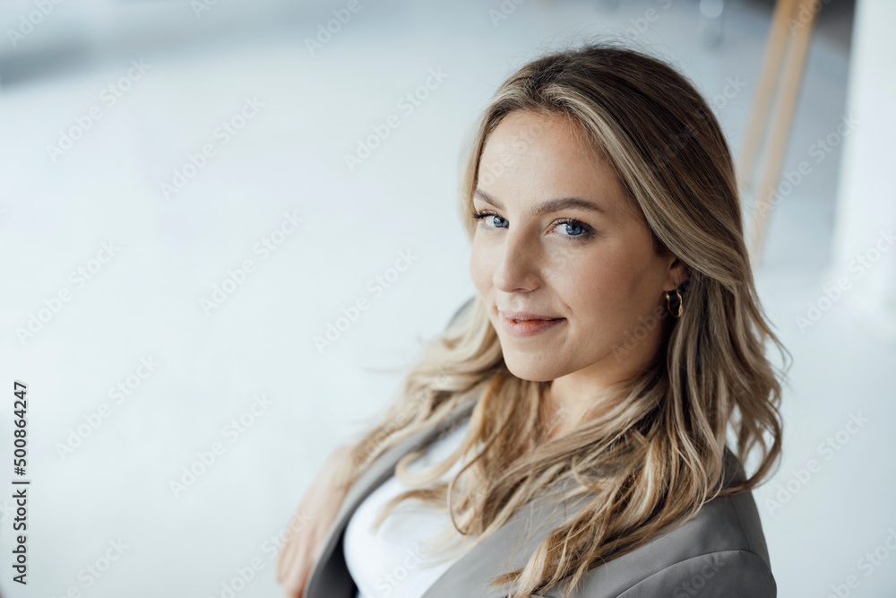 Smiling businesswoman with blond hair in office Smiling businesswoman with blond hair in office