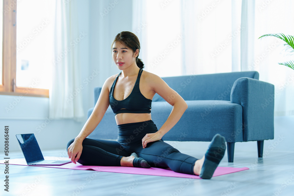 stress relief, muscle relaxation, breathing exercises, exercise, meditation, portrait of Young Asian woman relaxing her body from office work by practicing yoga by watching online tutorials. stress relief, muscle relaxation, breathing exercises, exercise, meditation, portrait of Young Asian woman relaxing her body from office work by practicing yoga by watching online tutorials.