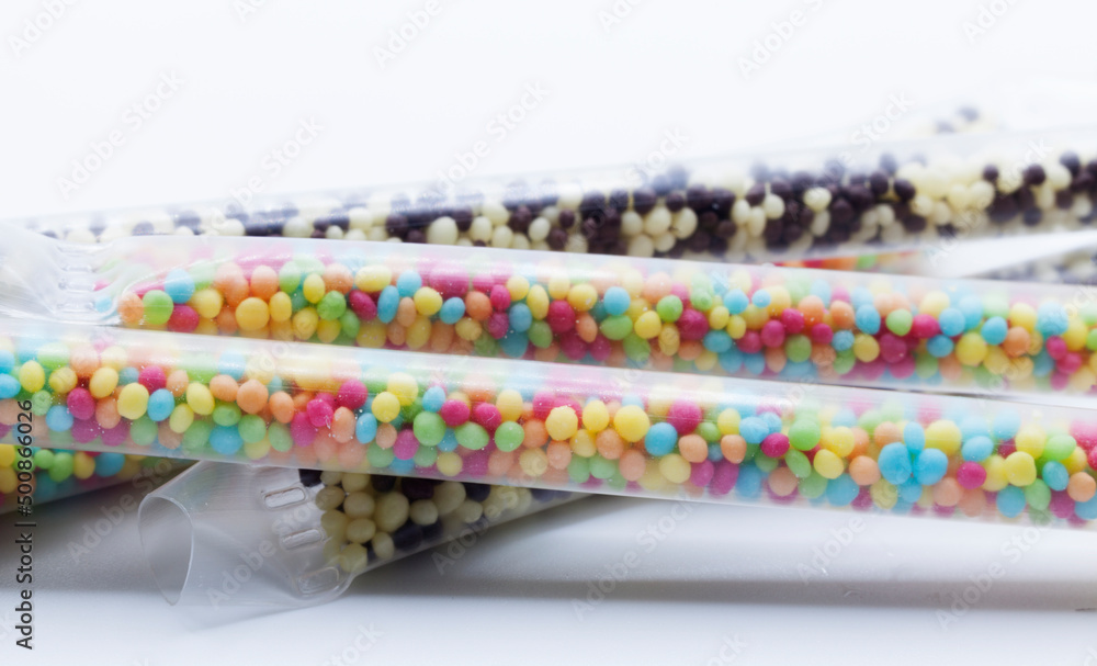several straws filled with small candies that give milk taste