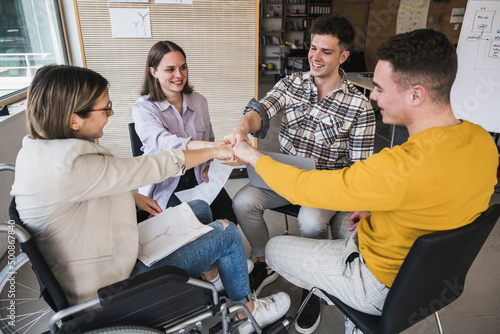 Business team touching fists in office photo