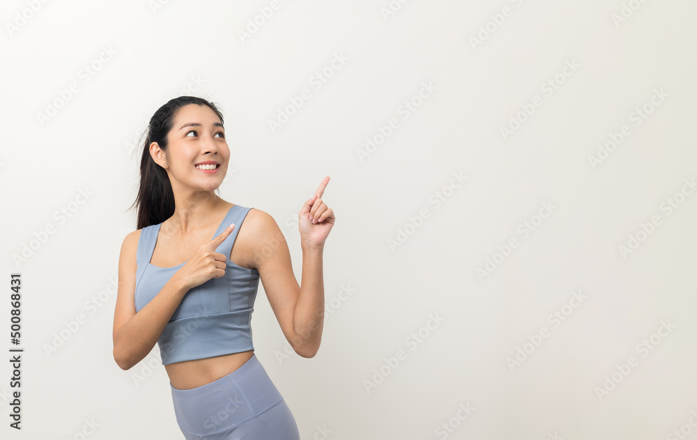 Young beautiful asian woman with sportswear on isolated white background. Portrait sporty woman standing pose exercise workout in studio. Pointing finger to blank space for advertise text. Young beautiful asian woman with sportswear on isolated white background. Portrait sporty woman standing pose exercise workout in studio. Pointing finger to blank space for advertise text.