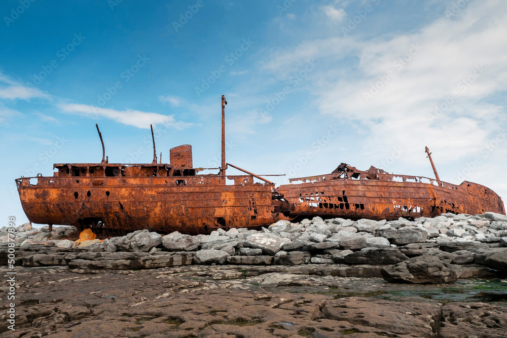 Plassey shipwreck on shore of Inisheer island. Aran islands, county Galway, Ireland. Rough stone coast and blue cloudy sky. Popular tourist landmark and attraction. Irish landscape