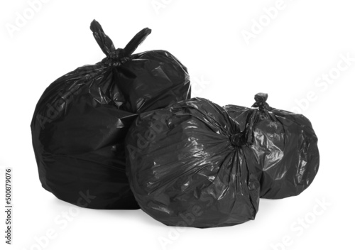 Black trash bags full of garbage on white background