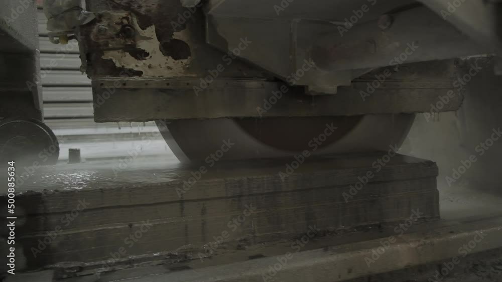 Huge round blade cutting the armored concrete plate. Drops of water dripping from the working mechanism for cooling machine. Huge round blade cutting the armored concrete plate. Drops of water dripping from the working mechanism for cooling machine.