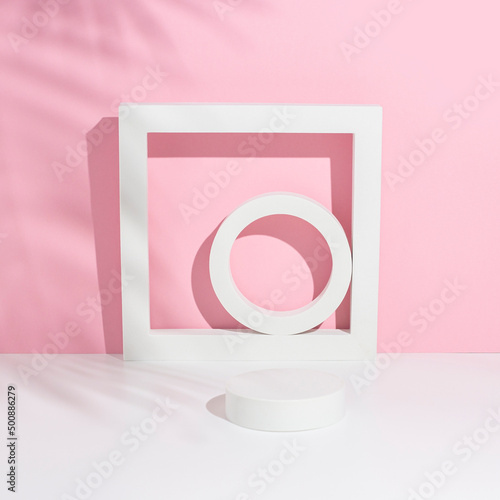 Podium white square, circles for presentation under the shadow of palm leaves on a white pink background