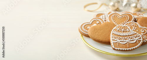 Tasty heart shaped gingerbread cookies on white wooden table  space for text. Banner design