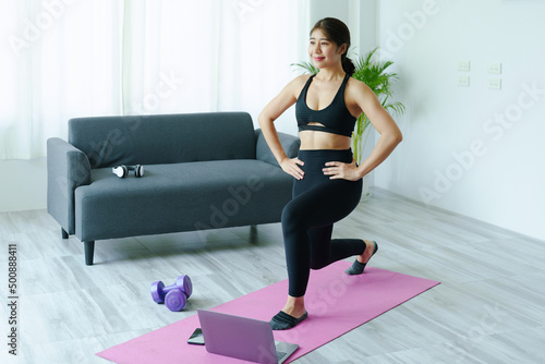 Fototapeta Naklejka Na Ścianę i Meble -  stress relief, muscle relaxation, breathing exercises, exercise, meditation, portrait of Young Asian woman relaxing her body from office work by practicing yoga by watching online tutorials.